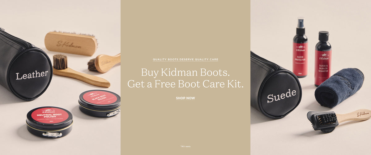 A promotional banner for Kidman Boots boot care, featuring leather and suede boot care items including a black cylindrical case labeled 'Leather' and 'Suede', two metal tins with red lids, wooden brushes, and two red spray bottles on a beige background with central text reading 'Buy Kidman Boots. Get a Free Boot Care Kit.